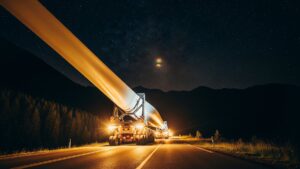 A truck transporting a giant blade the length of a Boeing 747 inches through a Colorado mountain town at midnight, and the giant machine waiting to replace that convoy is forcing engineers to rethink the sky itself 32 wind turbine blade transport convoy on a mountain road at night, boeing 747 inches