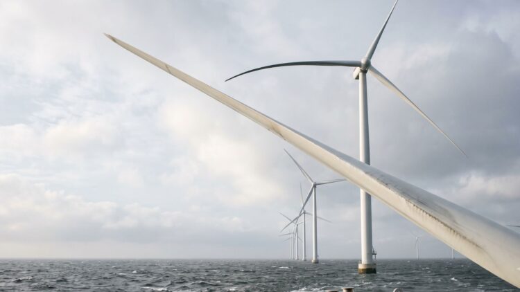 Wind turbines were promised as clean machines you build once and forget, but hundreds of feet up a hidden problem kept spreading, and the thing that finally climbed the sky to catch it was another machine 1 tall white wind turbines standing against a wide open sky over the sea