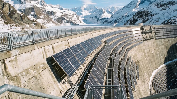 Switzerland bolted 5,000 solar panels onto a dam wall 8,000 feet up in the freezing Alps where everyone said solar made no sense, and the plant now makes three times more winter power than any farm down in the valleys 1 rows of solar panels bolted to a high dam wall among snowy alpine peaks
