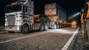 A power transformer weighing 460,000 pounds crossed 47 miles of Washington highway on a 360 foot trailer that weighed more than the transformer did, and the tightest stretch left a foot of road on each side 3 Crew walking beside a power transformer on a night highway haul