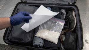 A traveler flying out of Phoenix moved 3 days of fiber powder into an unlabeled clear bag to stop it spilling, and the rule everyone cites about powders had nothing to do with why her suitcase was opened 2 An inspection notice lying on a clear bag of fiber powder