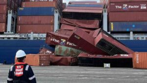A 95 box stack went into the water off a ship that was tied up and not moving, while the hour it chose was the one when the lashings were coming off 32 cargo ship container collapse at Port of Long Beach with oil sheen on harbor water, container ship tied