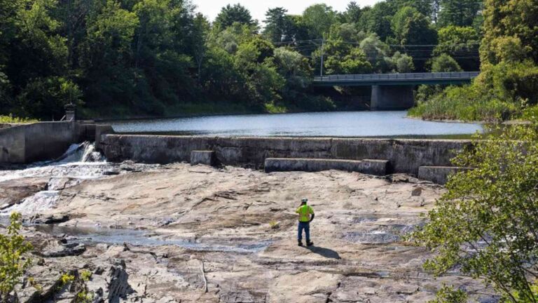 Excavator tearing down the Royal River dam during the Yarmouth removal project, 275 foot dam