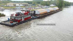 A brewery sent 12 tanks each 20 feet wide up a New York canal, and crews split the tow apart at every lock to fit it through 14 Tugboat and barge carrying a giant brewery tank through an Erie Canal lock during its journey, brewery sent 12