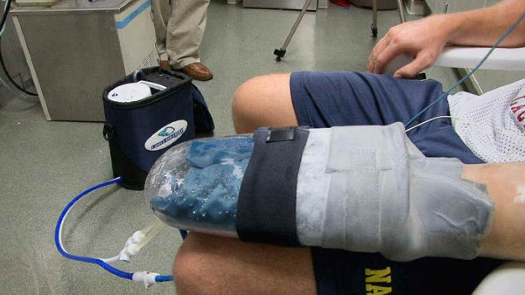 Research assistant using a palm cooling glove between pull-up sets in a university lab, lab volunteer who
