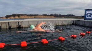 A Polish swimmer covered almost four miles of a flooded quarry lake in water just under 40 degrees, finishing in under two hours and extending the farthest ratified ice swim by about 82 feet 21 Swimmer mid stroke during record ice swim race through frozen lake water, polish swimmer covered