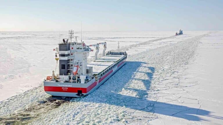 Cargo ship aground on Arctic shoal, Northwest Passage charts gap visible from shore, 564 foot cargo